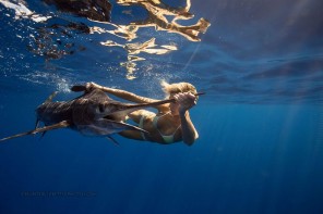 An underwater photo by Hunter Leadbetter of a woman swimming with a marlin to revive
