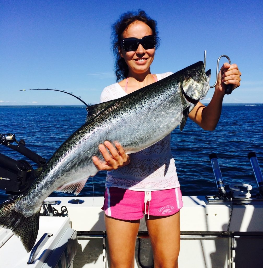 happy client with a trophy lake ontario lake trout from the Salmon River Lighthouse and marina